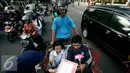Komunitas Gerakan Literasi Aksara Jawa membagikan kalender berhuruf Jawa kepada  pengunjung  pada peringatan Hari Aksara Internasional ke-50 di Titik Nol km, Yogyakarta, Kamis (8/9). (Liputan6.com/ Boy Harjanto)