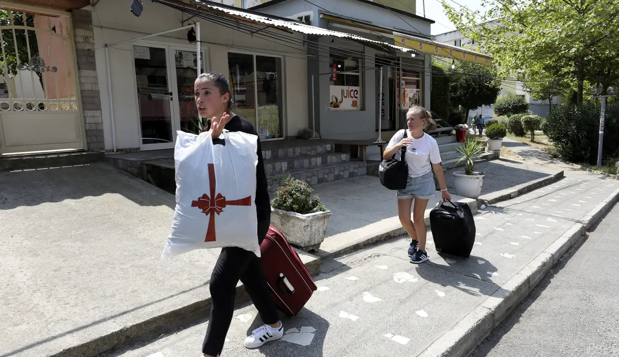 Mahasiswa meninggalkan kampus yang akan menampung warga Afganistan, di Tirana, Albania, Rabu (18/8/2021).  Albania sedang mempersiapkan kedatangan warga Afganistan yang bekerja dengan pasukan penjaga perdamaian Barat di Afganistan yang terancam oleh Taliban. (AP Photo/Franc Zhurda)
