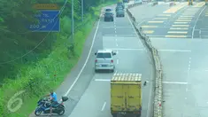 Pengendara motor berusaha memutar arah setelah memasuki Tol Ulujami - Serpong, Tangerang Selatan, Jumat (14/4). Minimnya rambu dan penjagaan petugas, membuat pengendara motor tersebut terjebak masuk ke jalur menuju pintu Tol. (Liputan6.com/Helmi Afandi)