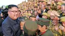 Pemimpin Korea Utara Kim Jong-un tersenyum saat bertemu veteran perang pada acara Konferensi Veteran Perang Nasional ke-5 di pemakaman perang Martyrs Cemetery di Pyongyang (27/7). (KCNA Via KNS/AFP)