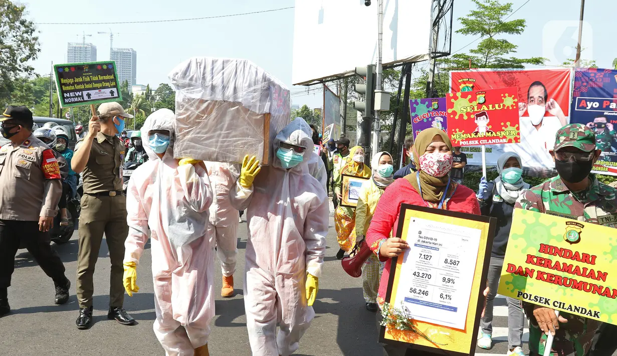 Petugas gabungan dari Kecamatan Cilandak dan Polsek Cilandak mengarak instalasi peti mati jenazah Covid-19 di kantor kecamatan Cilandak, Jakarta, Jumat (28/8/2020). Sosialisasi tersebut dilakukan untuk memberikan peringatan akan bahaya penularan virus Covid-19. (Liputan6.com/Herman Zakharia)