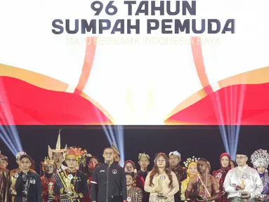 Atlet angkat besi Rizki Juniansyah (tengah) bersama pemuda-pemudi berprestasi saat puncak Hari Sumpah Pemuda ke-96 di Taman Mini Indonesia Indah (TMII), Jakarta, Senin (28/10/2024). (Liputan6.com/Herman Zakharia)