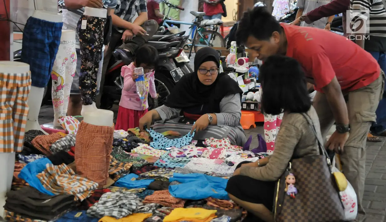 Warga memilih pakaian di kawasan perbelanjaan Pasar Baru, Jakarta Pusat, Rabu (21/6). Menjelang lebaran, kawasan perbelanjaan Pasar Baru mulai diserbu warga untuk berbelanja kebutuhan lebaran. (Liputan6.com/Yoppy Renato)