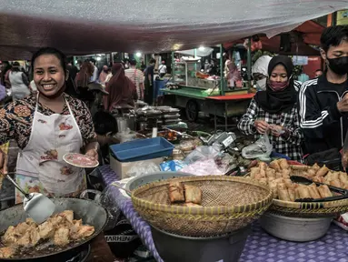 Pedagang menggoreng makanan saat menunggu pembeli sajian untuk berbuka puasa atau takjil di Pasar Rawamangun, Jakarta Timur, Rabu (14/4/2021). Pasar Rawamangun menjadi salah satu lokasi favorit warga untuk mencari aneka makanan dan minuman untuk sajian berbuka puasa. (merdeka.com/Iqbal S. Nugroho)