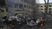 Sebuah mobil terbakar di sisi rumah sakit bersalin yang rusak akibat serangan udara di Mariupol, Ukraina (9/2/2022). Serangan Rusia telah merusak parah sebuah rumah sakit bersalin di kota pelabuhan Mariupol yang terkepung, kata pejabat Ukraina. (AP Photo/Evgeniy Maloletka)