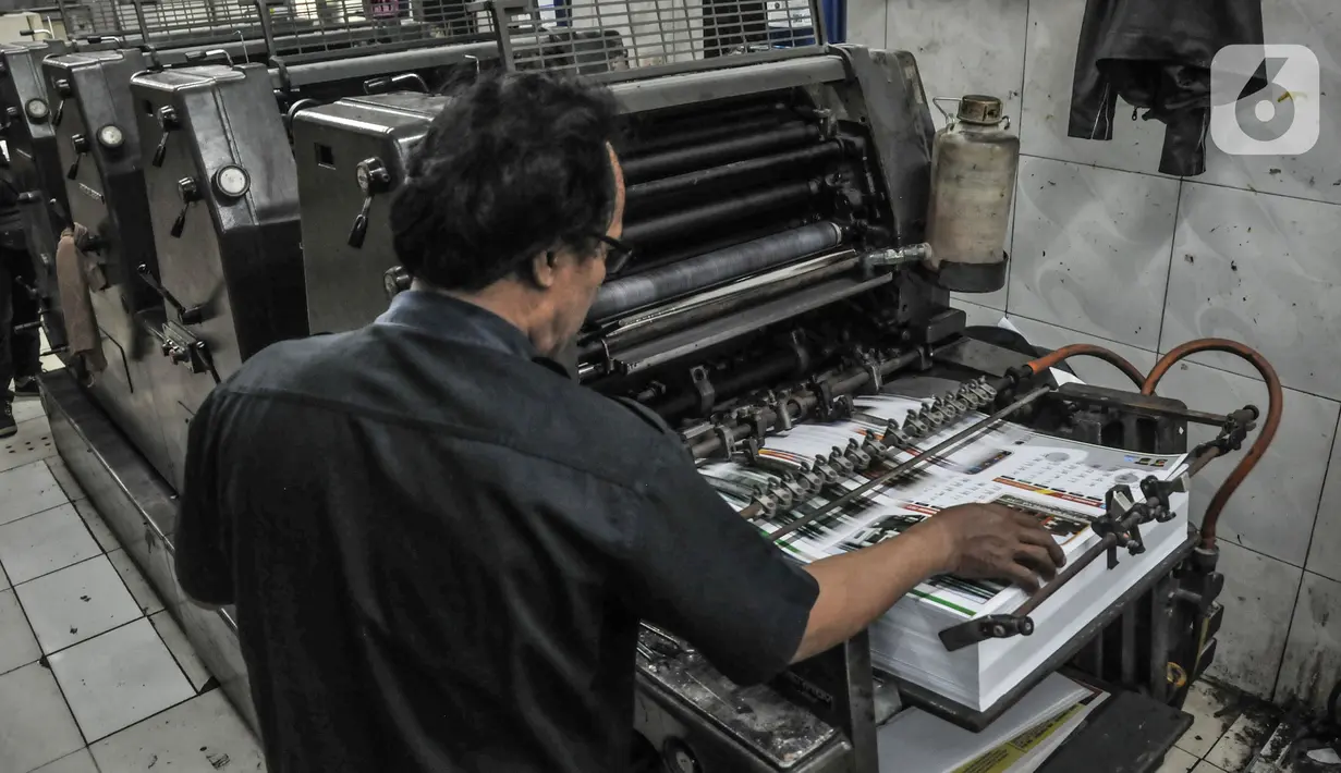 Pekerja mengerjakan pesanan pembuatan kalender 2022 di toko percetakan kawasan Senen, Jakarta, Senin (27/12/2021). Jelang tahun baru 2022 permintaan kalender meningkat hingga 20 persen dibandingkan tahun sebelumnya. (merdeka.com/Iqbal S Nugroho)