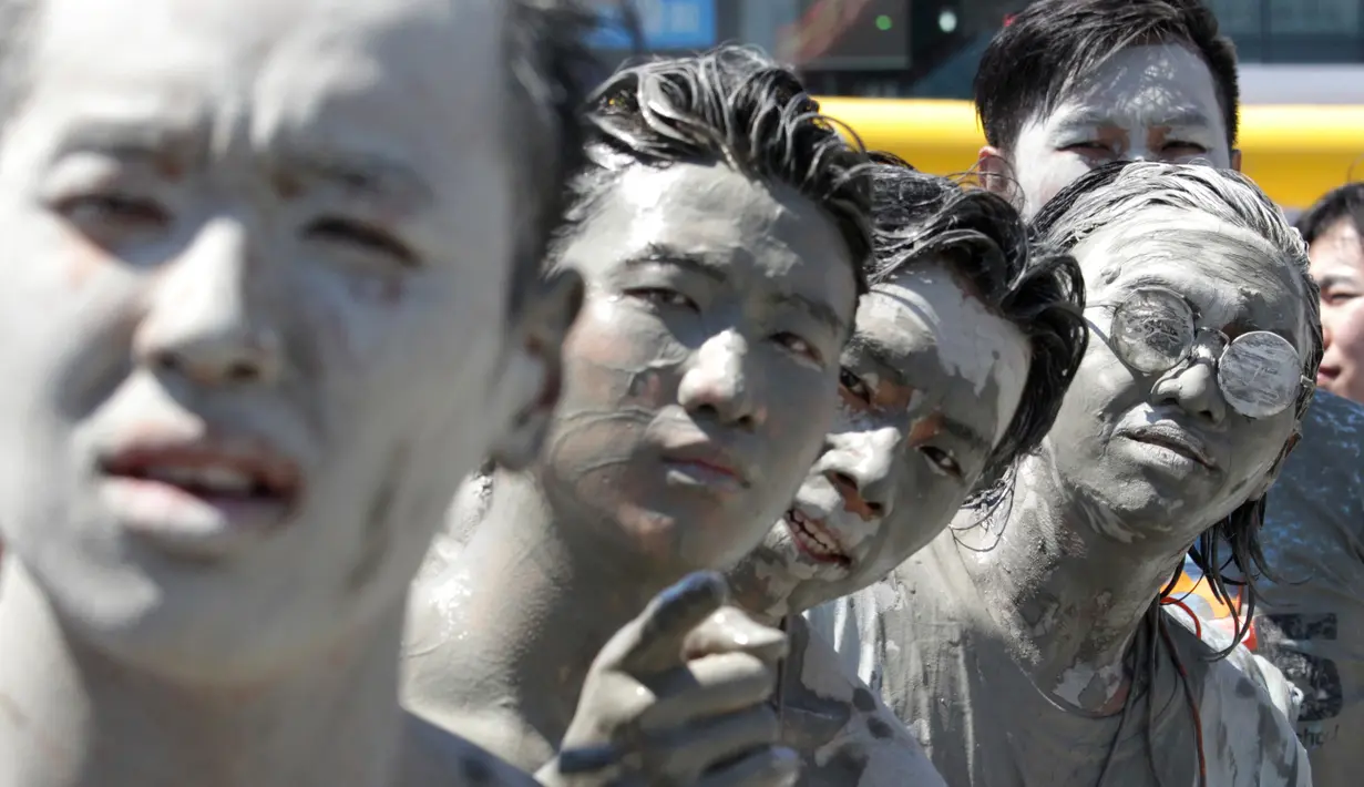 Wajah sejumlah orang yang terkena air lumpur selama Festival Lumpur Boryeong di Pantai Daecheon di Boryeong, Korea Selatan, (14/7). Festival lumpur tahunan ke-21 ini menampilkan gulat lumpur. (AP Photo / Ahn Young-joon)