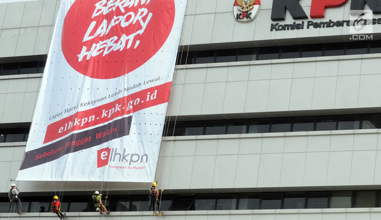 Empat orang aktivis membentangkan spanduk raksasa di gedung C Komisi Pemberantasan Korupsi (KPK) di Jakarta, Senin (26/3). Spanduk ini bertujuan mengimbau para pejabat untuk melaporkan harta kekayaan mereka. (Merdeka.com/Dwi Narwoko)