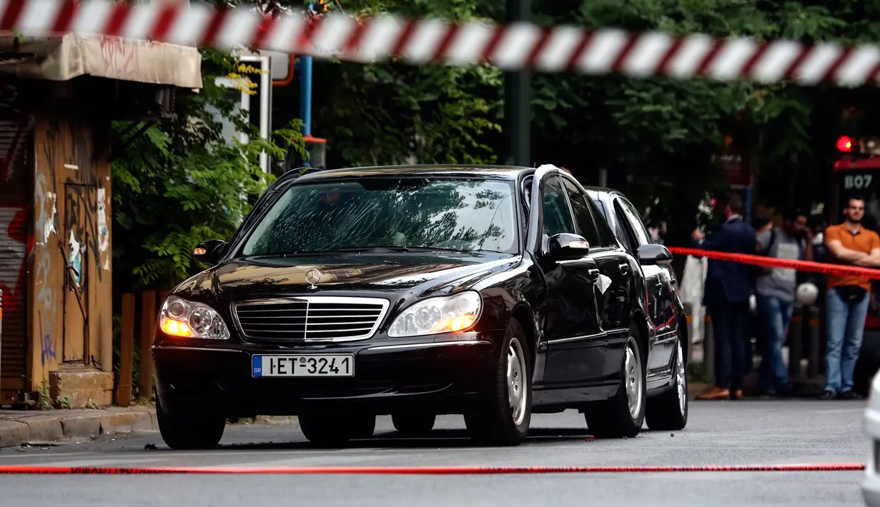 Sebuah mobil yang ditumpangi mantan PM Yunani, Lucas Papademos, terparkir di lokasi ledakan di Athena, Kamis (25/5). Sebuah benda yang disembunyikan dalam amplop meledak di mobil Papademos saat sedang melaju di pusat kota. (AP Photo/Yorgos Karahalis)
