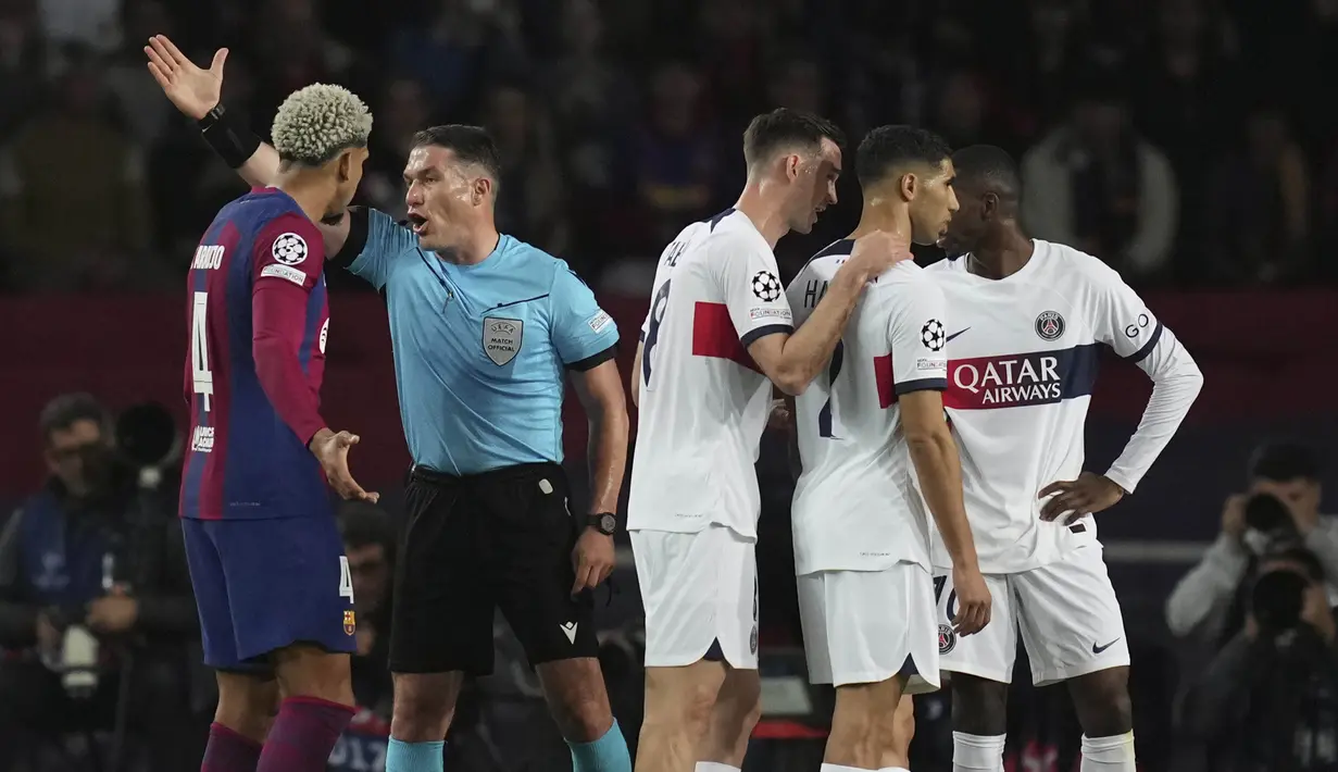 Wasit Istvan Kovacs mempersilahkan pemain Barcelona, Ronald Araujo keluar lapangan setelah memberikan kartu merah saat melawan Paris Saint-Germain pada duel leg kedua perempat final Liga Champions 2023/2024 Stadion Olimpic Lluis Companys, Rabu (17/4/2024). Barca tersingkir dari Liga Champions karena kalah agregat 4-6. (AP Photo/Emilio Morenatti)