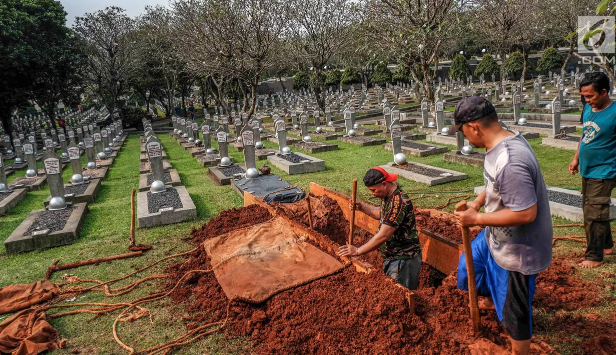Petugas menggali tanah untuk makam almarhumah Ani Yudhoyono, istri Presiden Ke-6 RI yang berada di Blok M 129 Taman Makam Pahlawan (TMP) Kalibata, Jakarta, Sabtu, (01/6/2019). Ani Yudhoyono meninggal di National University Hospital (NUH) pada pukul 11.50 waktu Singapura. (Liputan6.com/Faizal Fanani)