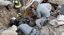 Sejumlah petugas dibantu warga menolong seorang pria yang tertimbun reruntuhan bangunan akibat gempa di Amatrice, Italia tengah, (24/8). Sekitar enam orang tewas akibat gempa tersebu. (REUTERS/Remo Casilli)