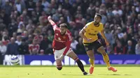 Bek Manchester United, Noussair Mazraoui, berduel dengan penyerang Wolves, Matheus Cunha, dalam laga pekan ke-33 Premier League 2024/2025 di Old Trafford, Minggu (20/4/2025). MU kalah 0-1 dalam pertandingan ini. (Martin Rickett/PA via AP)