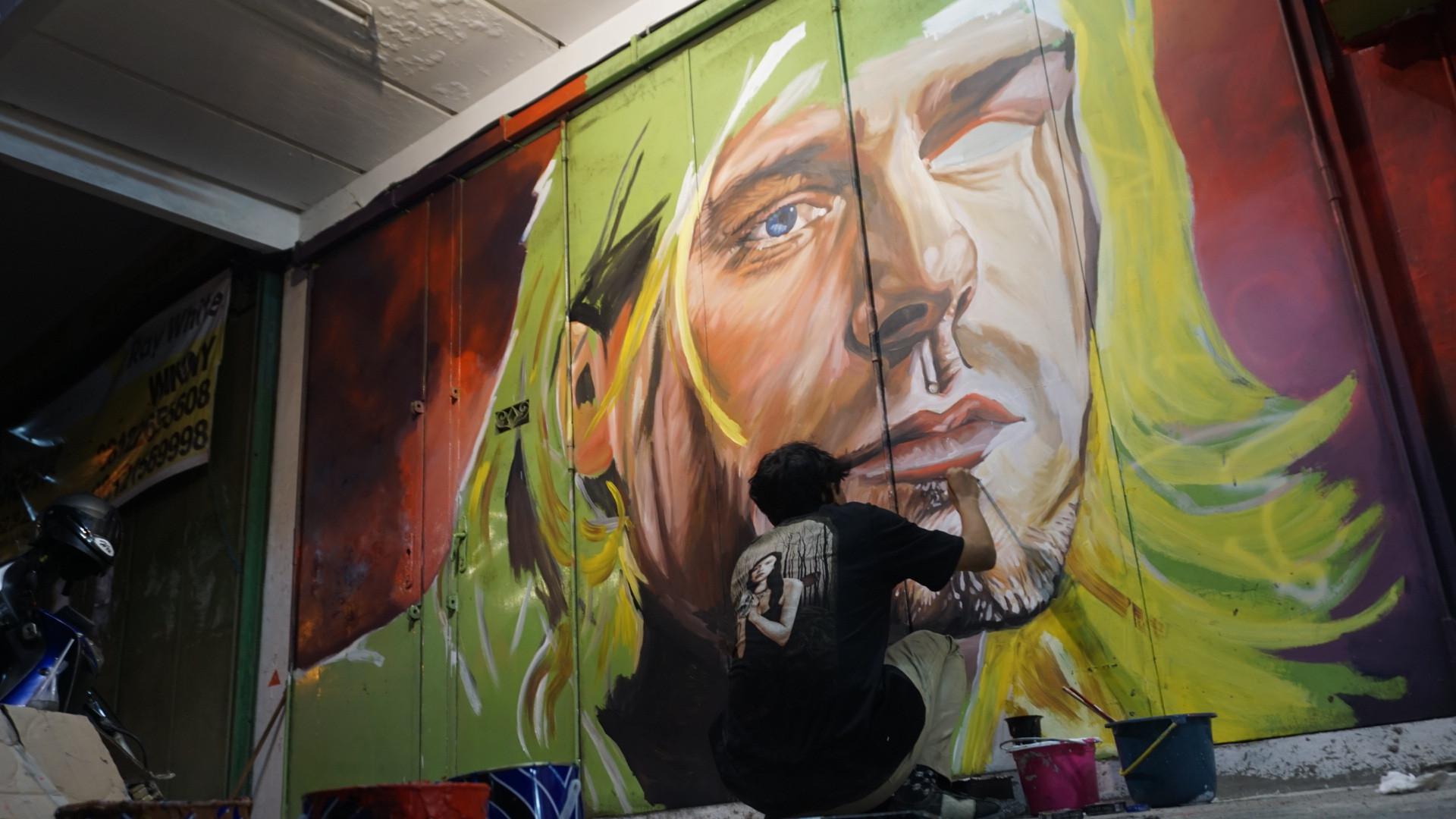 Sejumlah anak muda di Solo sedang menyelesaikan lukisan mural di tembok maupun pintu pertokoan yang terletak di Jalan Gatot Subroto, Solo.(Liputan6/Fajar Abrori)
