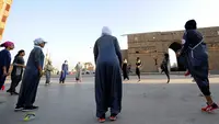 Perempuan Arab Saudi pemanasan sebelum jogging dalam memperingati Women's Day atau Hari Perempuan Internasional di Distrik Al-Balad, Jeddah, Kamis (8/3). Perempuan Arab Saudi menyambut baik sejumlah kebebasan yang diberikan. (Amer HILABI/AFP)