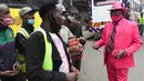 Fashionista Kenya, James Mwangi Maina berbincang sambil memamerkan setelan jasnya yang senada dengan pakaian dan aksesorisnya, termasuk masker di jalanan Nairobi, 5 Agustus 2020. Mwangi memiliki lebih dari 160 jas yang warnanya serasi dengan aksesoris yang dimilikinya. (Simon MAINA/AFP)