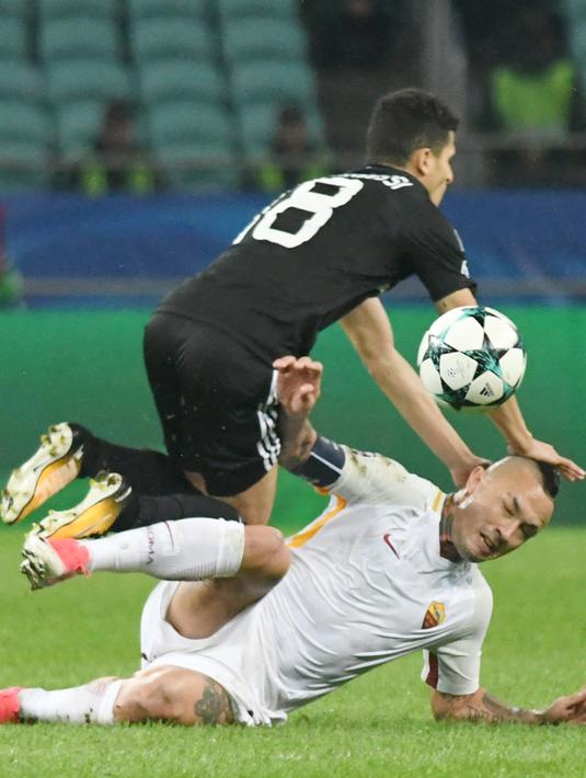 Pemain Qarabag FK, Tarik Elyounoussi (atas) menghindari terjangan pemain AS Roma, Radja Nianggolan pada laga grup C Liga Champions di Baki Olimpiya Stadionu, Baku, (27/9/2017). AS Roma menang 2-1. (AFP/Vano Shlamov)