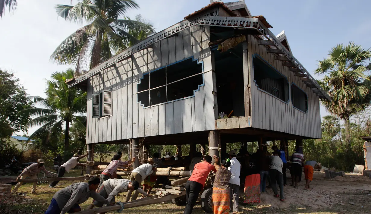 Sejumlah warga mendorong rumah di Desa Serey Andet di provinsi Kampong Speu, Kamboja (27/3). Pindah rumah dengan cara tradisional ini bagian dari budaya di Desa Serey Andet. (AP Photo/Heng Sinith)