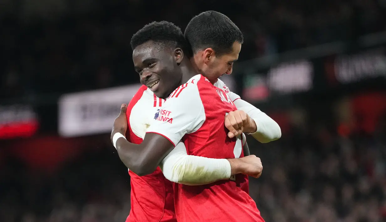Pemain Arsenal, Mikel Merino (kiri) berpelukan dengan Bukayo Saka setelah memberikan assist dalam laga lanjutan Liga Inggris 2025/2026 melawan Brentford di Emirates Stadium, London, Inggris, Rabu (03/12/2025) waktu setempat. (AP Photo/Kirsty Wigglesworth)