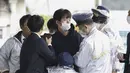 Seorang pria yang diyakini sebagai tersangka ditangkap di tempat kejadian pada hari Sabtu. (Kyodo News via AP)
