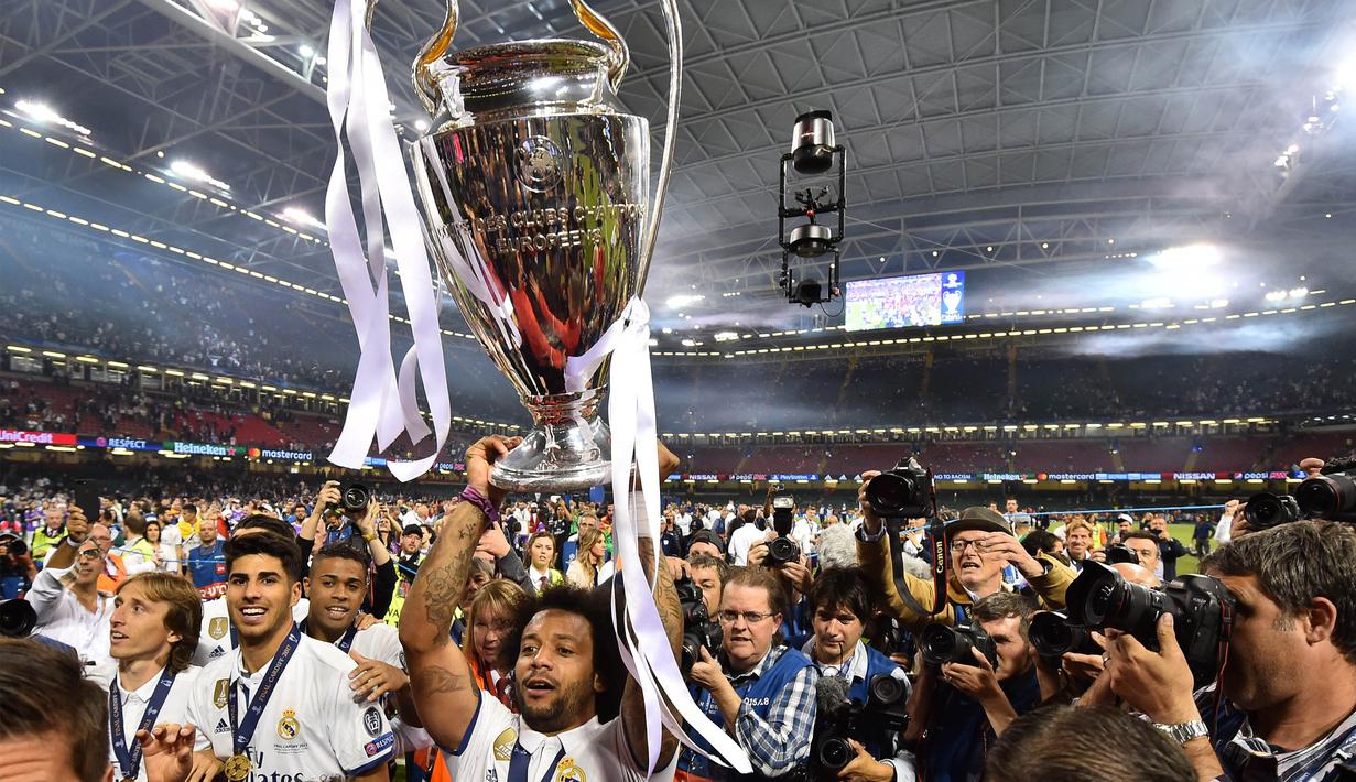 Bek Real Madrid, Marcelo, menangkat trofi merayakan gelar juara Liga Champions bersama rekan-rekannya di Stadion Millenium, Cardiff, Sabtu (3/6/2017). Madrid menang 4-1 atas Juventus. (AFP/Glyn Kirk)