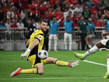 Kiper Timnas Indonesia, Maarten Paes, berusaha menghalau bola tendangan Pemain Arab Saudi, Saleem Al Dawsari, pada laga Grup B putaran keempat Kualifikasi Piala Dunia 2026 Zona Asia di King Abdullah Sports City Stadium, Jeddah, pada Kamis (9/10/2025) dini hari WIB. (AP Photo)