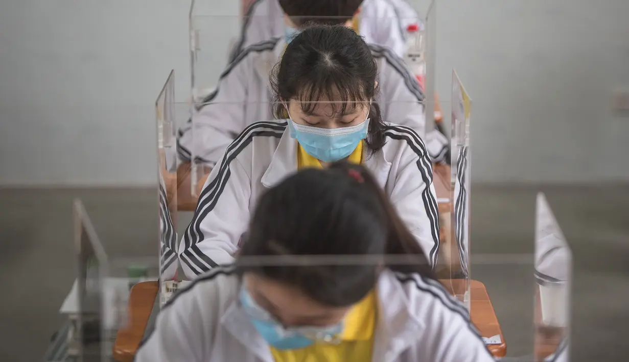 Siswa belajar dengan pemisah pada masing-masing meja mereka sebagai langkah pencegahan penyebaran COVID-19 di Sekolah Menengah No. 23 Wuhan, Wuhan, Provinsi Hubei, China, Rabu (6/5/2020). Sekitar 57.800 siswa tingkat akhir dari 121 SMA dan kejuruan di Wuhan kembali bersekolah. (Xinhua/Xiao Yijiu)