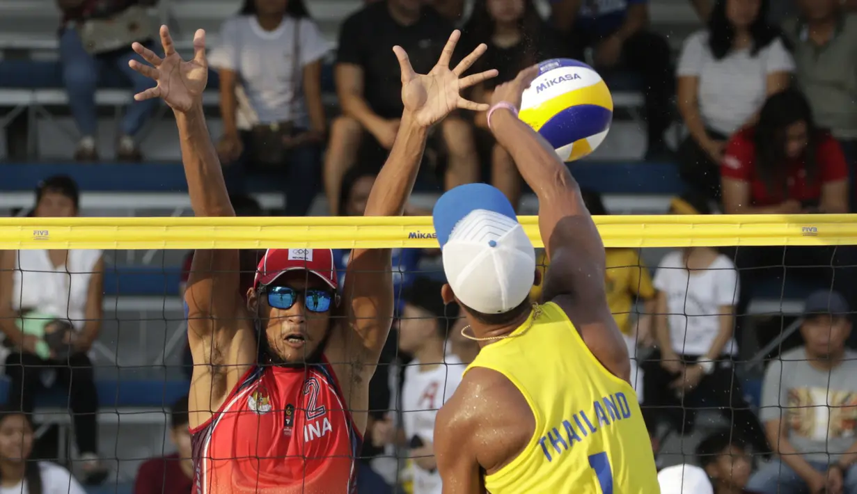 Pevoli pantai Indonesia, Ade Chandra, melakukan block saat melawan Thailand pada laga final voli pantai beregu putra SEA Games di Subic Court Tennis, Filipina, Jumat (6/12). Indonesia berhasil meraih emas. (Bola.com/M Iqbal Ichsan)