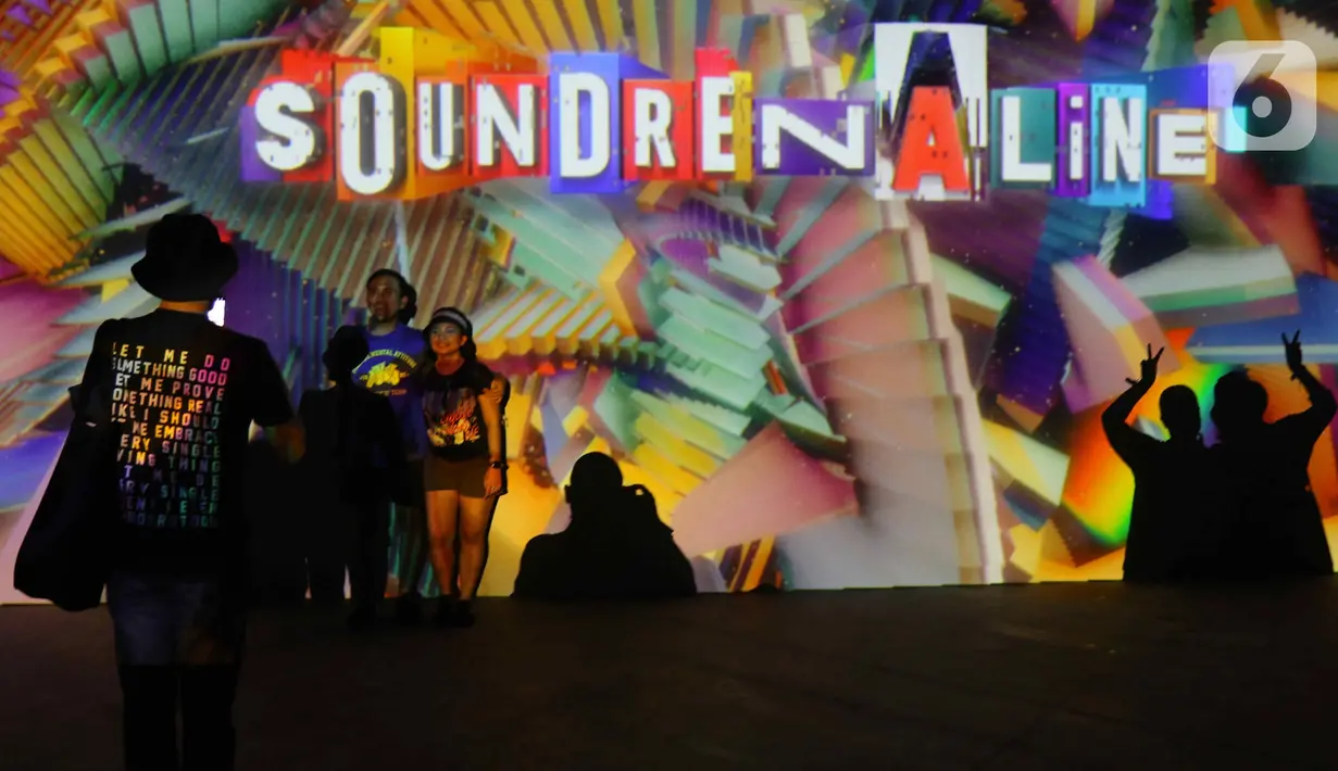 Pengunjung berfoto saat memasuki area festival musik Soundrenaline 2022 di Allianz Ecopark, Ancol, Jakarta Utara, Sabtu (26/11/2022). Festival musik Soundrenaline 2022 menampilkan musisi seperti Hollow Coves, Weezer, Neck Deep, Clean Bandit, Isyana Sarasvati, Pure Saturday yang berlangsung pada 26 dan 27 September 2022. (Liputan6.com/Herman Zakharia)