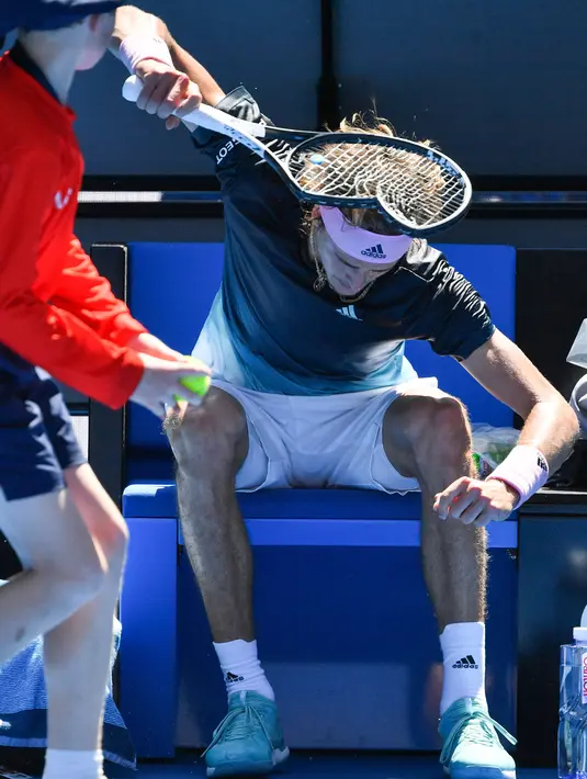 Petenis Jerman, Alexander Zverev membanting raketnya hingga rusak saat beristirahat pada putaran keempat Australia Terbuka  menghadapi Milos Raonic dari Kanada di Melbourne, Senin (21/1). Zverev frustasi setelah kalah dua set 6-1 4-1. (Paul Crock/AFP)