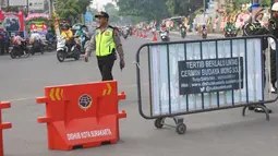 Petugas kepolisian melakukan pengalihan arus lalu lintas di Jalan Letjen Suprapto, Solo, Rabu (8/11). Jalan menuju gedung Graha Saba akan dialihkan dan ditutup selama proses pernikahan Kahiyang Ayu dan Bobby Nasution. (Liputan6.com/Angga Yuniar)