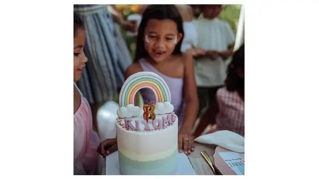 Kue ulang tahun Kiyomi bertema rainbow, ia tampak begitu bahagia melihatnya.