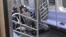 Seseorang dibantu dalam gerbong kereta bawah tanah di wilayah Brooklyn, New York, Amerika Serikat, 12 April 2022. Seorang pria bersenjata memenuhi kereta bawah tanah pada jam sibuk dengan asap dan menembak beberapa orang. (Will B Wylde via AP)
