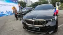 Sekretaris Kementerian Sekretariat Negara (Kemensetneg) Setya Utama bersama President Director BMW Group Indonesia Ramesh Divyanathan saat penyerahan mobil listrik BMW i7 dan i5 di komplek GBK, Senayan, Jakarta, Jumat (3/5/2024). (Liputan6.com/Angga Yuniar)