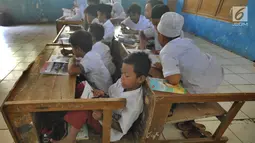 Murid-murid kelas V melakukan kegiatan belajar pada meja yang diubah menjadi kursi dan tempat belajar di SDN Kertajaya 2, Rumpin, Bogor (22/7/2019). Sekolah dengan jumlah 280 murid  dan hanya berjarak sekitar 50 km dari ibukota ini tidak dilengkapi WC dan perpustakaan. (merdeka.com/Arie Basuki)