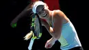 Petenis Denmark, Caroline Wozniacki berusaha melepas rambutnya yang tersangkut raket pada sesi latihan menjelang Grand Slam Australia Terbuka di Melbourne, Minggu (14/1). Grand slam tersebut bakal berlangsung 15-28 Januari 2018. (AP/Vincent Thian)