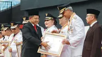 Gubernur Jawa Tengah, Ganjar Pranowo saat menerima penghargaan yang diberikan Menteri Dalam Negeri, Tito Karnavian pada Peringatan Hari Otonomi Daerah (Otda) XXVII.