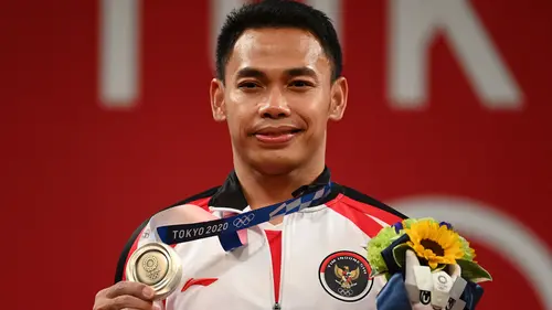 Pada Olimpiade Tokyo 2020, Eko Yuli Irawan yang berlomba di kelas 61 kg berhasil mempertahankan prestasinya dengan kembali meraih medali perak dengan angkatan total 302 kg. (AFP/Vincenzo Pinto)