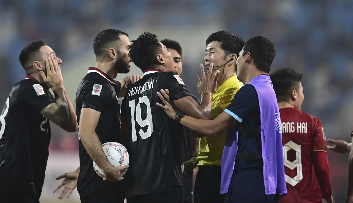 Provokasi yang dilakukan ofisial Vietnam yang berada di pinggir lapangan (kanan) saat pemain Timnas Indonesia, Fachruddin Aryanto melakukan protes ke wasit. (AP Photo/Nguyen Manh Quan)
