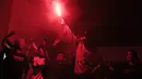 Seorang penonton menyalakan suar saat nonton bareng Manchester United melawan Arsenal. (Bola.com/Vitalis Yogi Trisna)