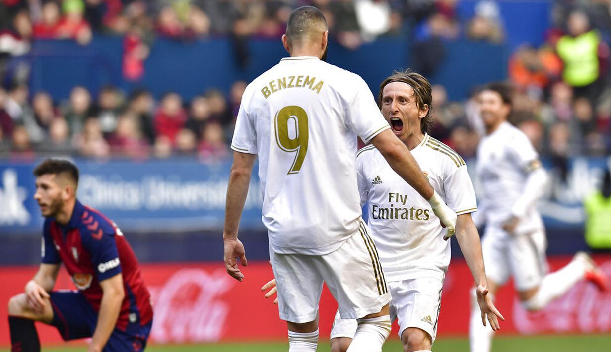 Pemain Real Madrid, Luka Modric bersama Karim Benzema merayakan gol ke gawang Osasuna pada laga La Liga di Stadion El Sadar, Minggu (9/2/2020). Real Madrid menang 4-1 atas Osasuna. (AP/Alvaro Barrientos)