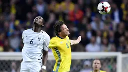 Gelandang Prancis, Paul Pogba berebut bola udara dengan gelandang Swedia, Albin Ekdal saat bertanding pada kualifikasi Piala Dunia 2018 di Friends Arena, Solna, Stockholm (9/6). Swedia menang atas Prancis dengan skor 2-1. (Marcus Eriksson/TT via AP)