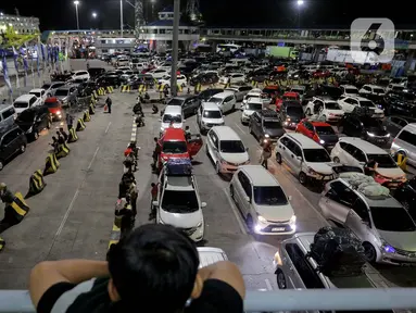 Seorang anak memperhatikan antrean mobil yang akan masuk ke dalam kapal penyeberangan di Pelabuhan Merak, Kota Cilegon, Banten, Jumat (28/3/2025) dini hari. (Liputan6.com/Herman Zakharia)