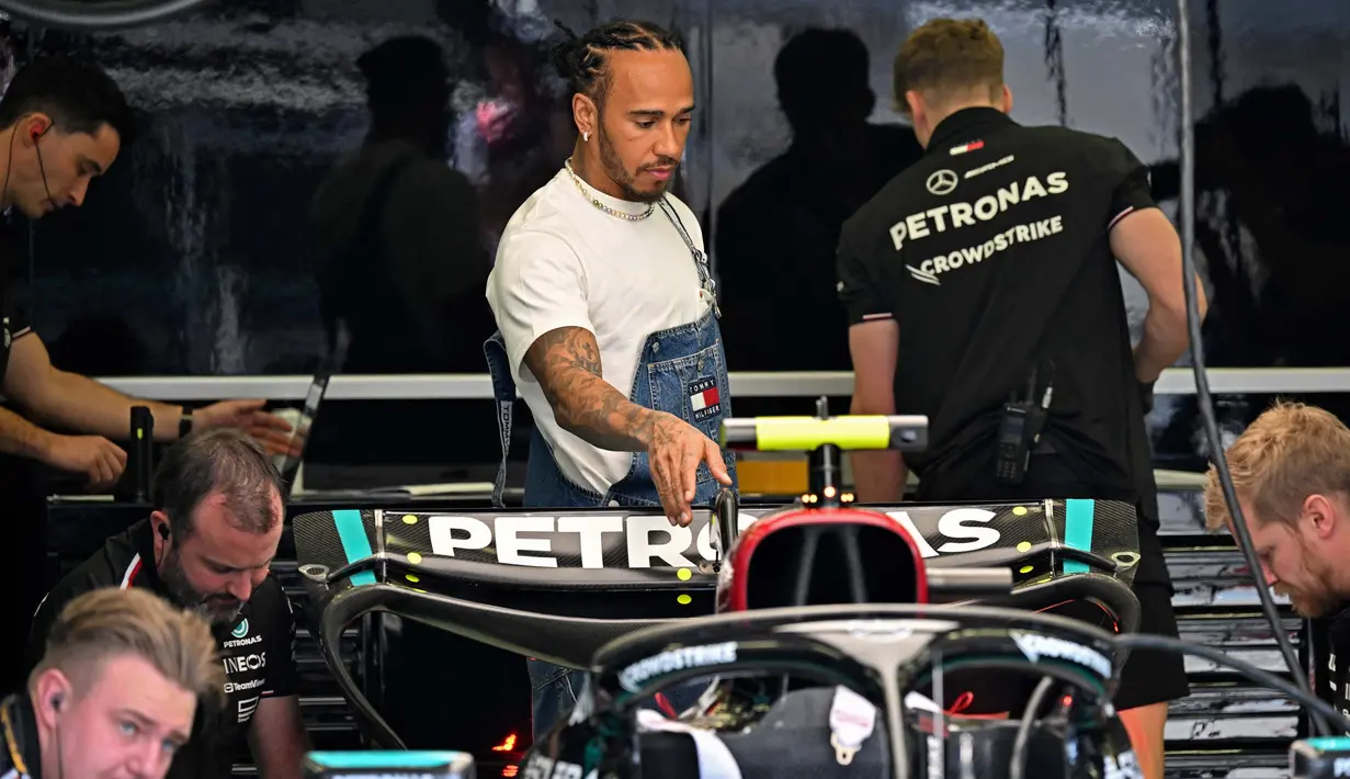 Pembalap Mercedes asal Inggris, Lewis Hamilton tiba di garasi menjelang sesi latihan pertama Grand Prix Formula1 Bahrain di Sirkuit Internasional Bahrain, Sakhir pada 29 Februari 2024. (ANDREJ ISAKOVIC/AFP)