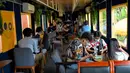 Foto yang diambil pada 5 Juni 2021 menunjukkan orang-orang duduk di dalam sebuah kafe, dari gerbong kereta, di stasiun kereta api di Phnom Penh. Gerbong kereta diubah menjadi kafe setelah selama pandemi corona sebagian besar perjalanan kereta api di Kamboja dihentikan. (TANG CHHIN Sothy/AFP)