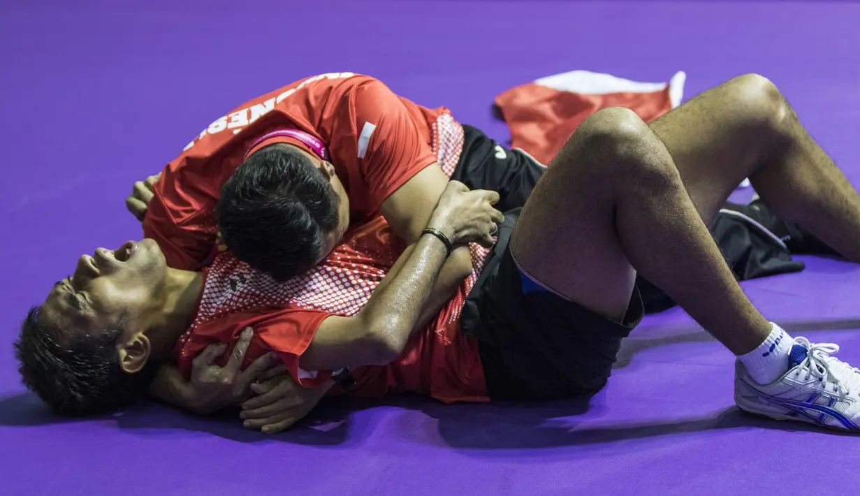 Petenis meja Indonesia, David Jacobs, bersama sang pelatih merayakan selebrasi usai meraih medali emas Asian Para Games cabang tenis meja TT 10 di Ecovention Ancol, Jakarta, Selasa (9/10/2018). (Bola.com/Vitalis Yogi Trisna)