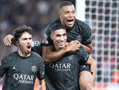 Para pemain Paris Saint-Germain (PSG) merayakan gol yang dicetak oleh Achraf Hakimi ke gawang Borussia Dortmund pada laga Liga Champions di Stadion Parc des Princes, Rabu (20/9/2023). PSG menang dengan skor 2-0. (AP Photo/Michel Euler)