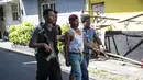 Petugas kepolisian mengamankan seorang pria mencurigakan di sekitar Mapolrestabes Surabaya, Jawa Timur, Senin (14/5). Sebelumnya, bom bunuh diri terjadi sekitar pukul 08.50 WIB di depan markas penjagaan Mapolrestabes Surabaya. (AFP/JUNI KRISWANTO)