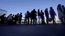 Para Migran Haiti menunggu bus setelah diproses di kamp darurat di Del Rio, Texas, Minggu (19/9/2021). Pemerintahan Presiden Joe Biden mendekati final berencana untuk mengusir ribuan migran Haiti yang tiba-tiba menyeberang ke kota perbatasan Texas dari Meksiko. (AP Photo/Eric Gay)