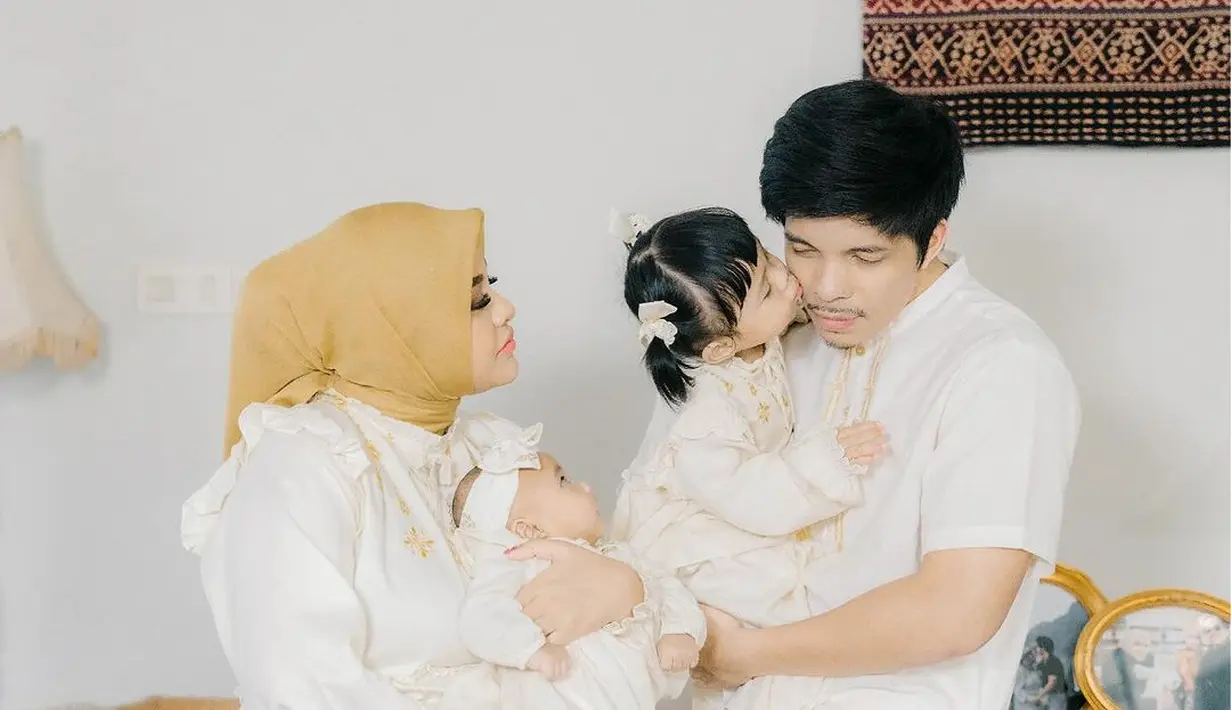 Aurel Hermansyah dan Atta Halilintar pilih nuansa putih sebagai seragam keluarga. Aurel kenakan dress putih dengan bordir cokelat emas dan hijab cokelat. [@aurel.hermansyah]